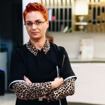 Stylish business owner with arms folded in front of business. 
