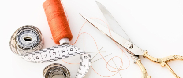 Measuring tape, scissors, and a roll of string on a desk. 