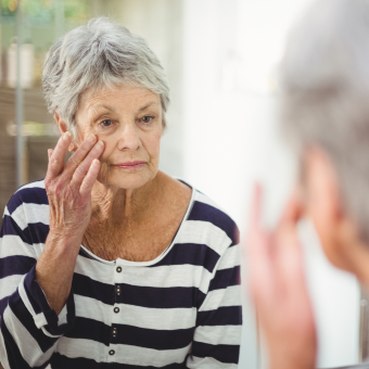 Woman rubbing on make up on her face. 