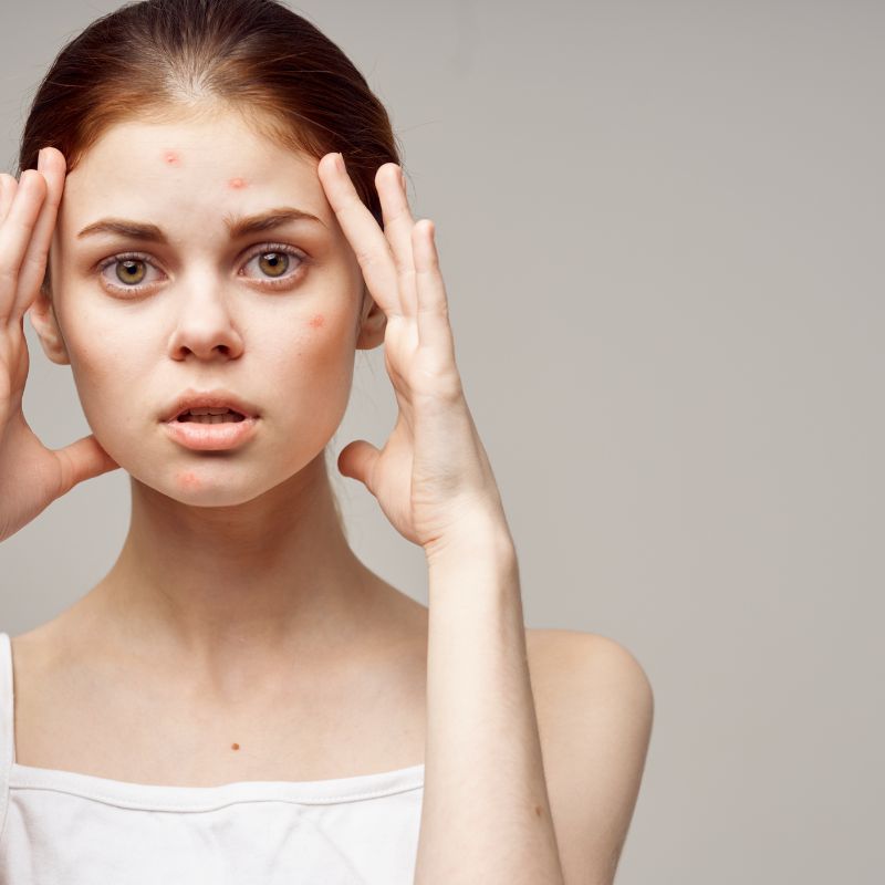 A person holding their hands to their head looking stressed.