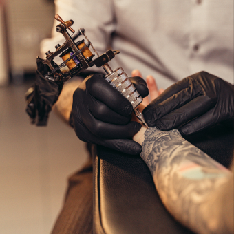 Tattoo artist working on a client