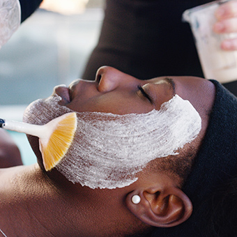 esthetician applying face masque to client