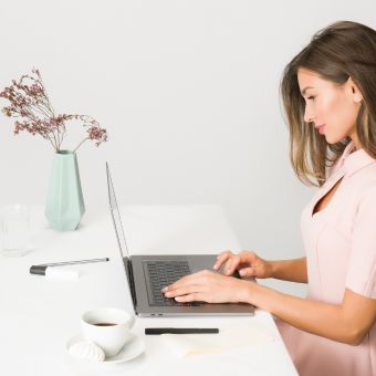 esthetician in pink uniform at computer