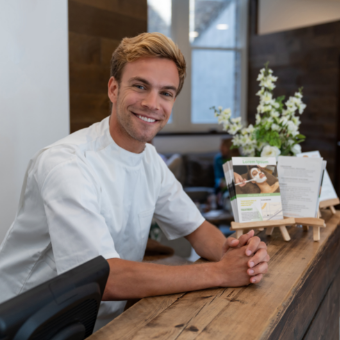 Male esthetician standing at the front desk