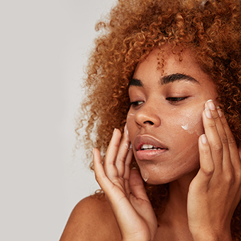 Curly Haired woman washing her face