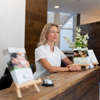 Business owner at the front desk with business brochures and spa menu
