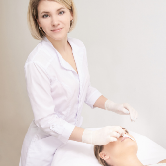 Esthetician applies wax to client's lip