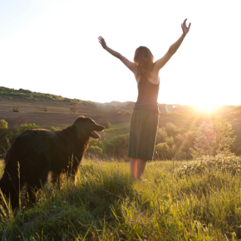 woman with her dog facing the sun