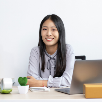 Woman sits at her desk with computer